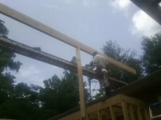 Carpenter setting a ridge beam over a new addition frame — Ice Dam Removal by Roofing Brothers in Valhalla