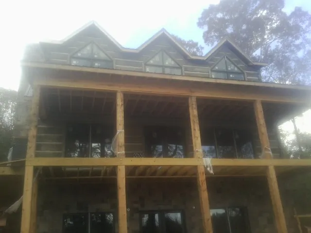 Dormers and porch framing on a large log home under construction — Roof Coating work by our crew in Valhalla